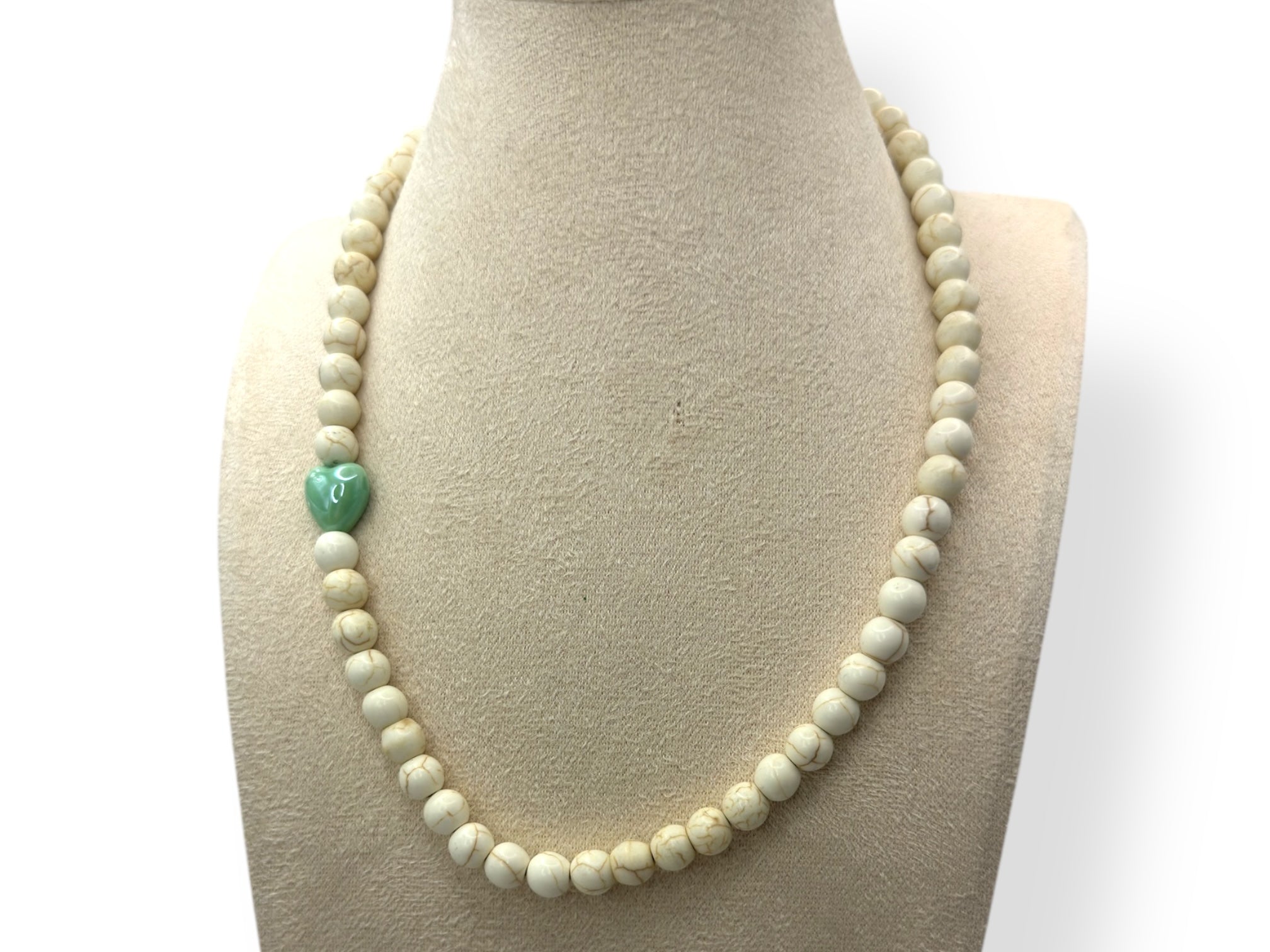 wit ketting met groen hartje close up